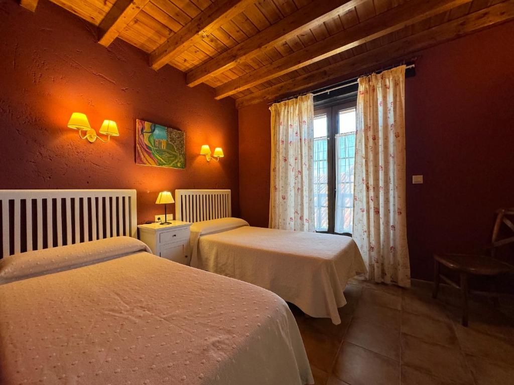 LuzmelaCasa Rural La Socarrena的一间卧室设有两张床和窗户。