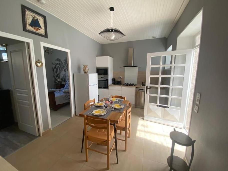 滨海勒维维耶Charmant logement avec 2 véranda的厨房以及带桌椅的用餐室。