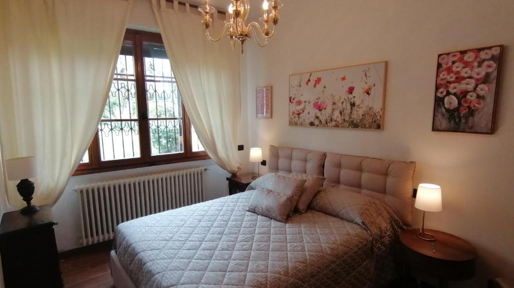 西尔米奥奈Villa Paradiso的一间卧室配有一张带两盏灯的床和一扇窗户。
