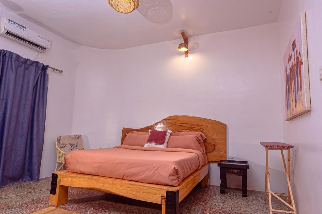 伊巴丹Bonsai Boutique Homes的一间卧室配有一张带木制床头板的床