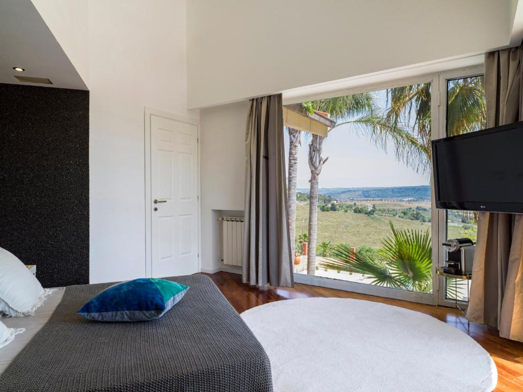 卡尔伦蒂尼Villa Nunziatina的一间卧室设有一张床和一个享有美景的大窗户