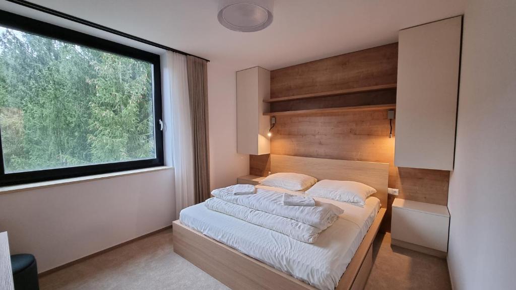 鲁容贝罗克Chalets Hrabovo的一间卧室设有一张大床和大窗户