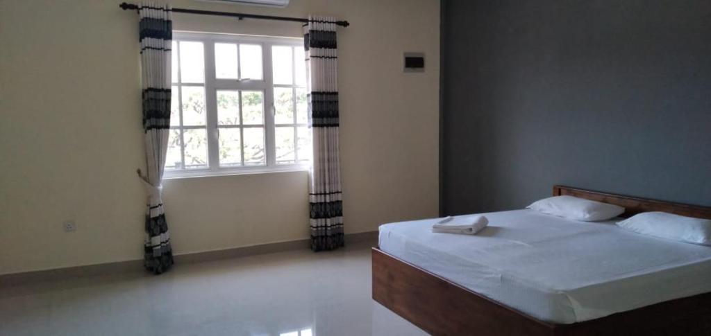 库鲁内格勒Saragama Apartment的一间卧室设有一张大床和窗户