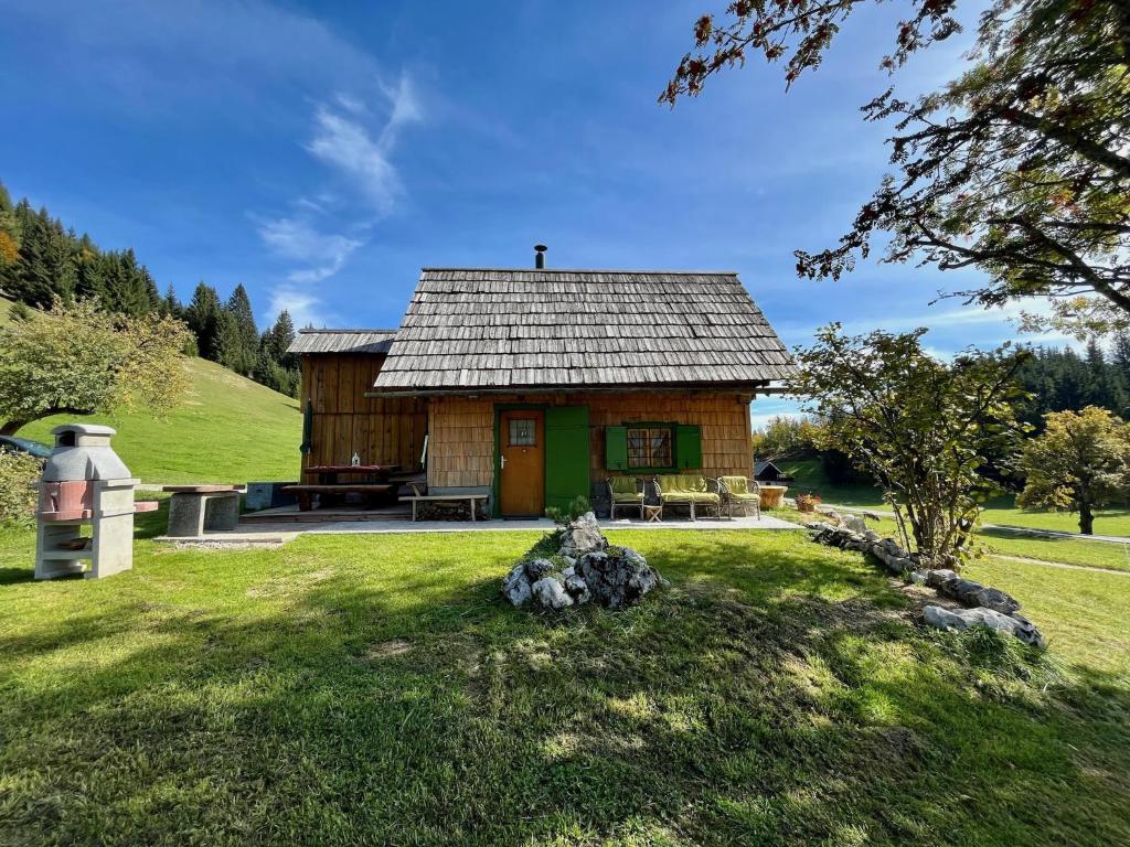 博希尼Chalet Hike&Bike above Bohinj valley的草场上的小小屋,有树