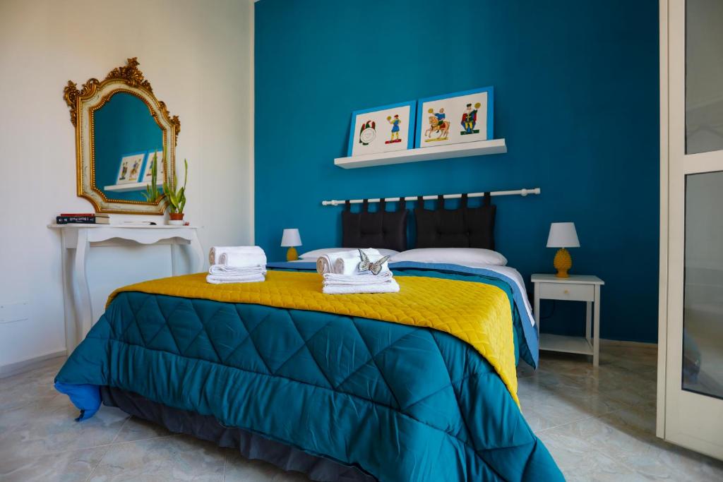 巴勒莫Biddizzi的一间蓝色卧室,配有一张床和镜子