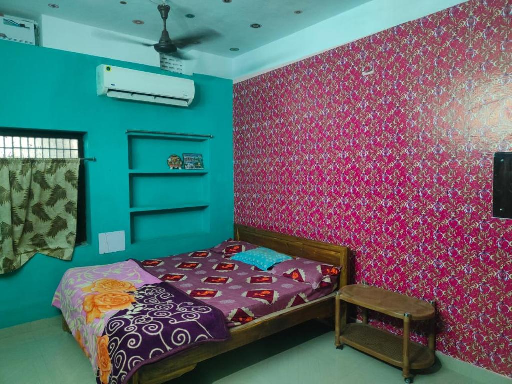 普里JHARANA GUEST HOUSE的一间卧室配有一张床和粉红色的墙壁