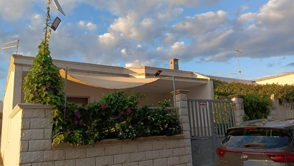 普罗斯西托角Casa Totò - Punta Prosciutto Apartment的一座带围栏的房子,前面有一辆汽车