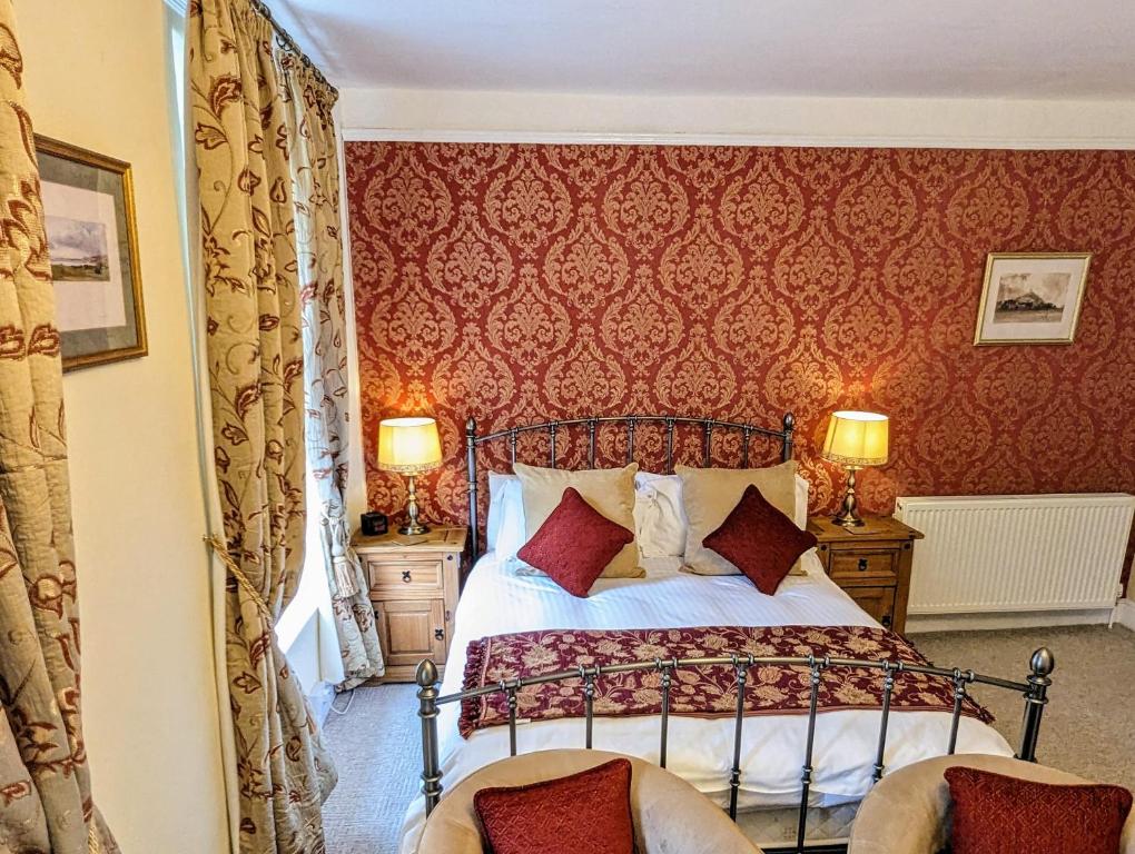 邓斯特埃克斯穆尔楼旅馆的一间卧室配有一张红色墙壁的床和两把椅子