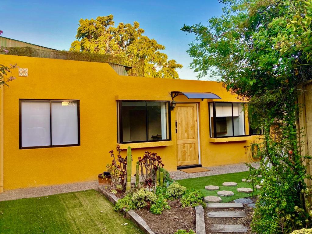圣地亚哥Urban Lodge Providencia的黄色的房子,前面有一个花园
