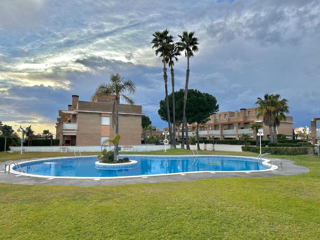 阿尔塔夫拉Villa Alex Altafulla Hermosa casa con espectaculares vistas al mar y a tocar de una idílica calita的一座棕榈树游泳池和一座建筑