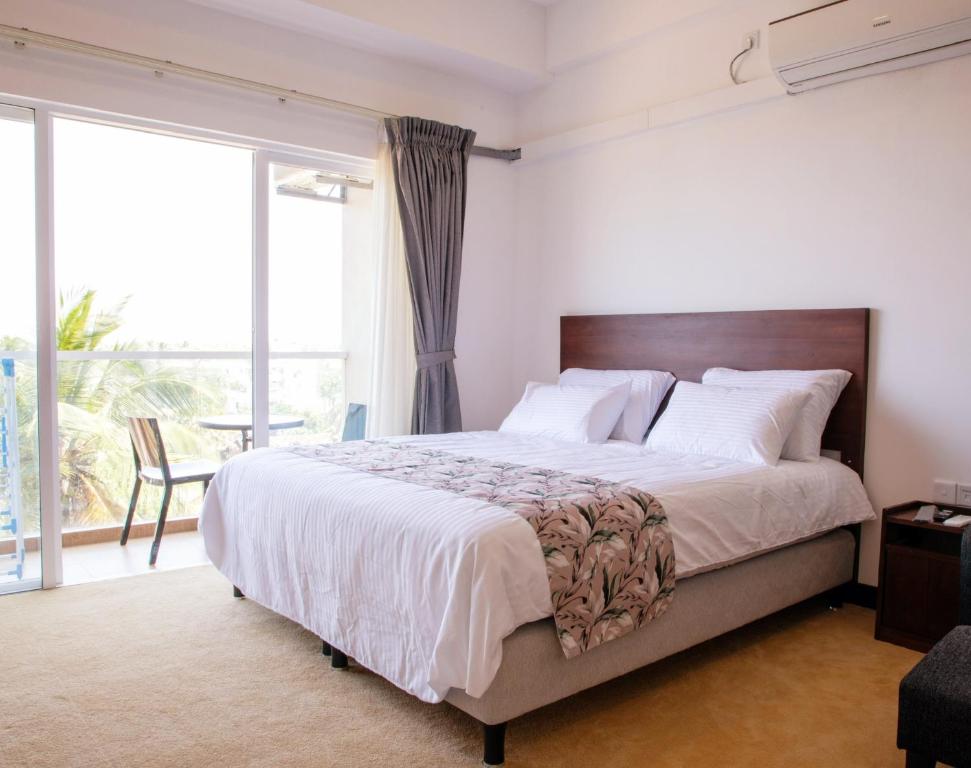 尼甘布Ocean Breeze Apartment Negombo, R 5, B16 Mina的一间卧室设有一张大床和一个大窗户