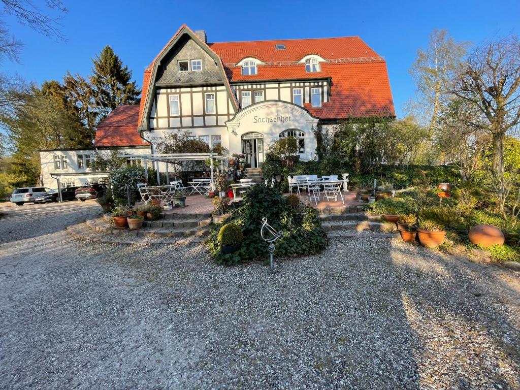 Klingbergromantische Ferienwohnung Sachsenhof 2的一座带橙色屋顶和一些植物的大房子