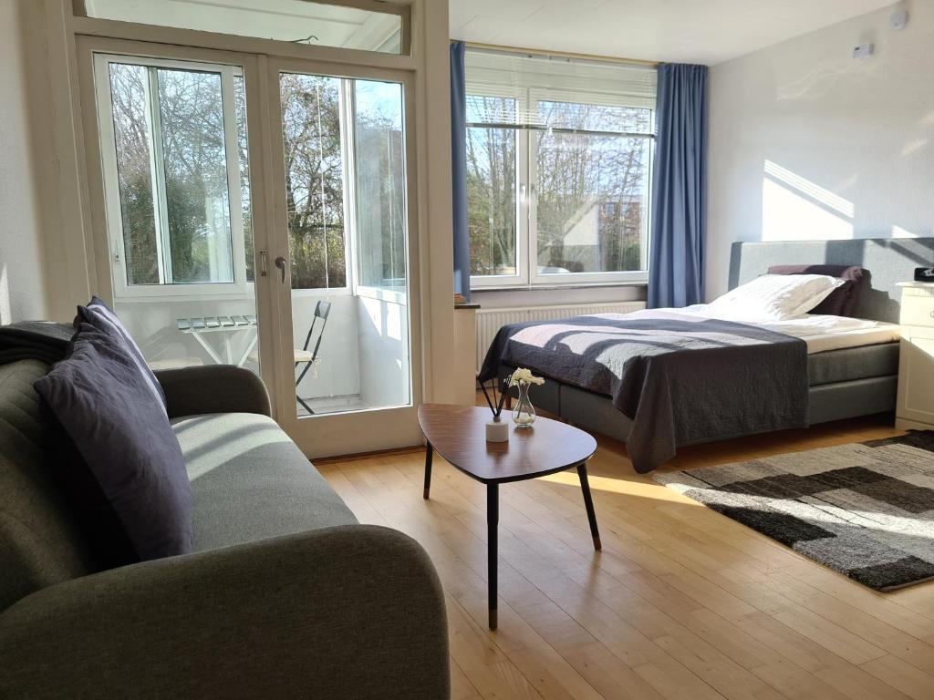 RødovreBayer Apartments Copenhagen的一间卧室配有一张床、一张沙发和一张桌子