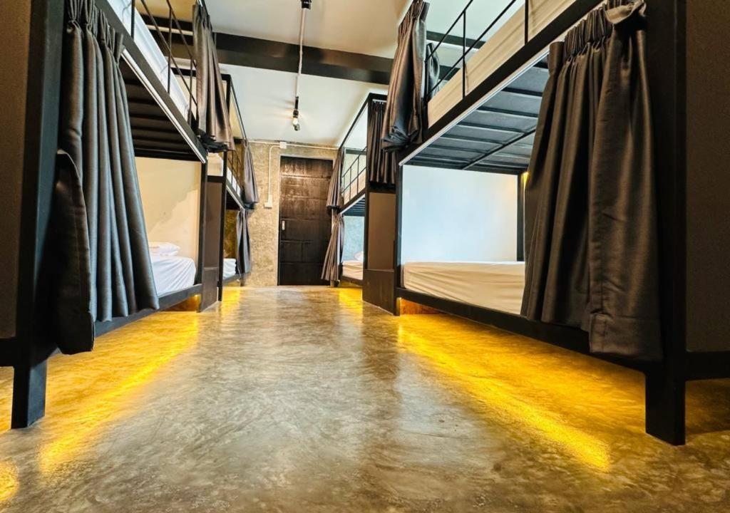 清迈Adora Hostel的走廊上设有三张双层床。