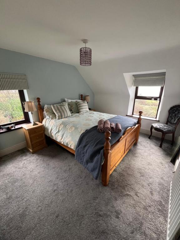 凯尔西温Seaview House Reenard South的一间卧室设有一张大床和两个窗户。