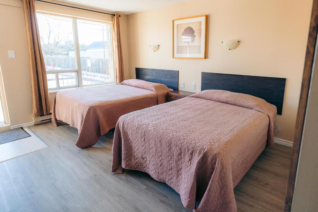 米西索加克拉克森村汽车旅馆 的酒店客房设有两张床和窗户。