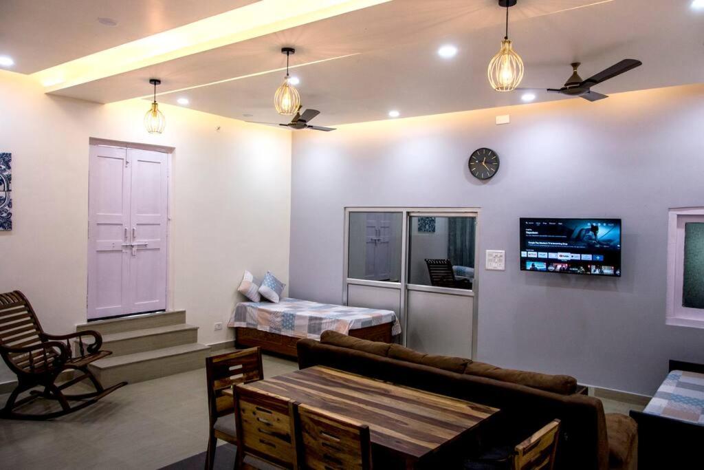 AyodhyaGooseberry Garden的客厅配有沙发和墙上的电视