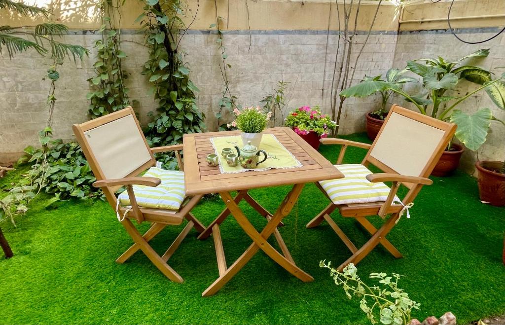 卡拉奇Mohalla Rooftop Retreat的两把椅子和一张木桌,桌子和桌子