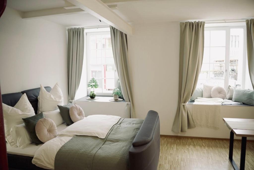 罗伊特林根De la vie Reutlingen - Altstadt Apartment an Stadthalle & am Marktplatz的一间卧室设有一张床和两个窗户。