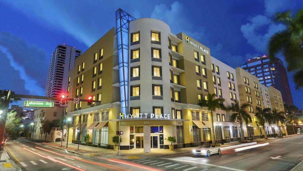 西棕榈滩西座落滩凯悦普雷斯酒店的城市街道上一座高大的建筑,上面有标志