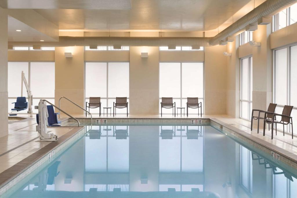 波特兰波特兰机场/喀斯喀特车站君悦酒店的大楼内一个带桌椅的游泳池