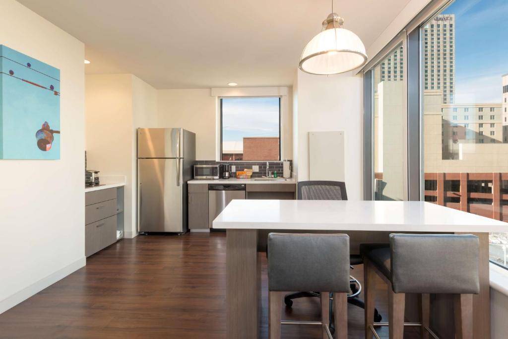 丹佛丹佛/市中心凯悦酒店的厨房配有桌椅和冰箱。