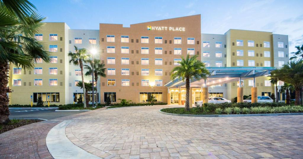 奥兰多Hyatt Place Orlando/Lake Buena Vista的一座棕榈树环绕的大酒店