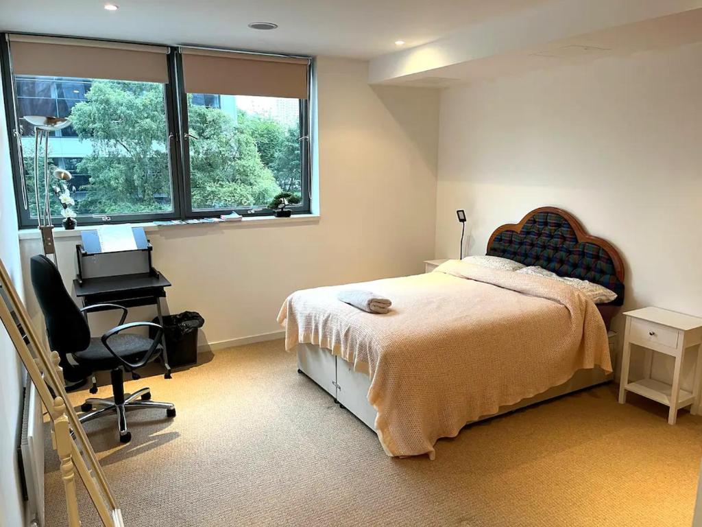 格拉斯哥Spacious Queen Bed City Centre Penthouse With Balcony - Homeshare - Live In Host的一间卧室配有一张床、一张书桌和一个窗户。