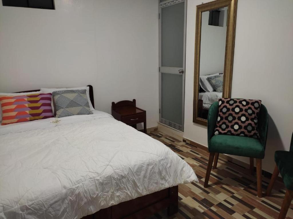 HuantaHOTEL HUANTA - MORENOS的一间卧室配有一张床、镜子和椅子