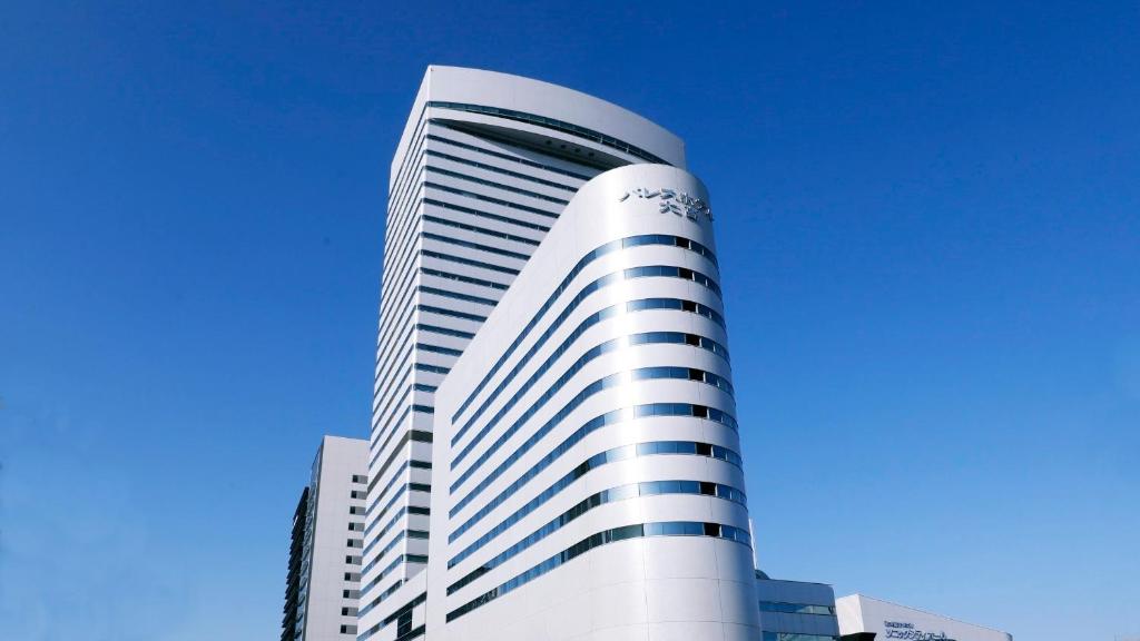 埼玉市皇宫大宫酒店的一座高大的白色建筑,背后是蓝天