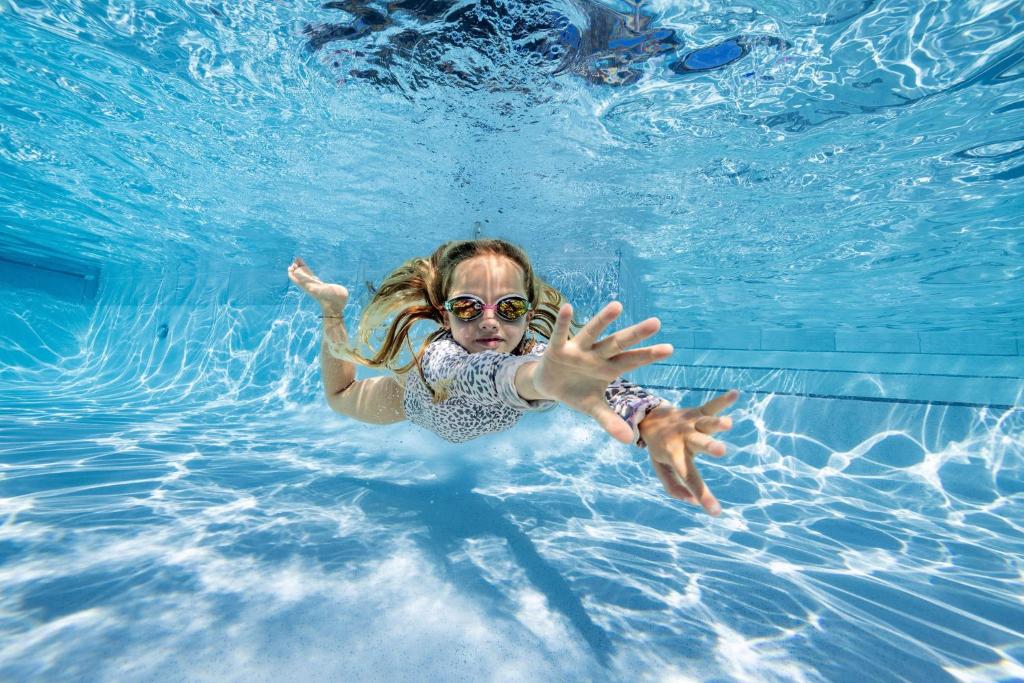 热水海滩热水海滩十佳度假酒店的一个小女孩在游泳池游泳