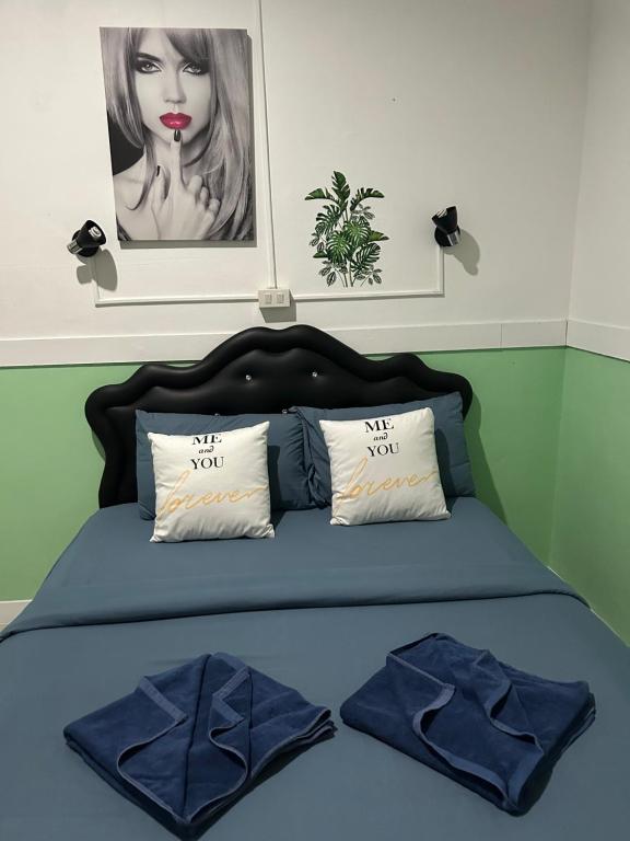 沙美岛Labella samet guesthouse的一张带蓝色棉被和两个枕头的床