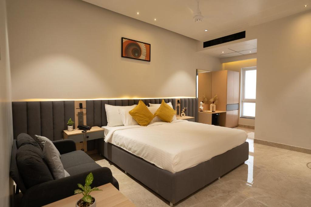 海得拉巴Hotel Kyzen Hi Tech City的一间卧室配有一张床和一张沙发