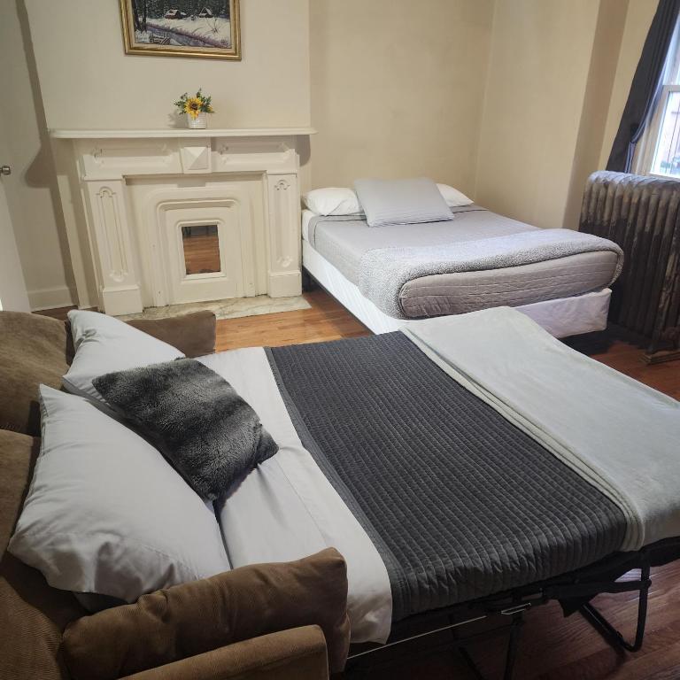 纽约New York City GuestHouse的带壁炉的客房内的两张床