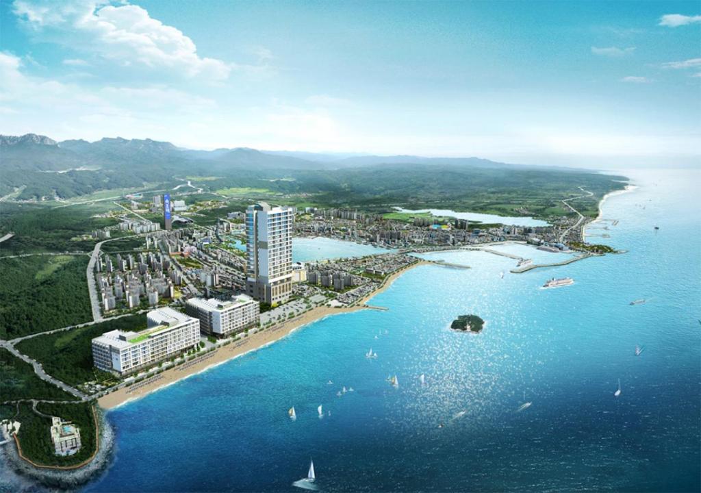 束草市Sokcho Chonpines Beach Hotel的水边城市的空中景观