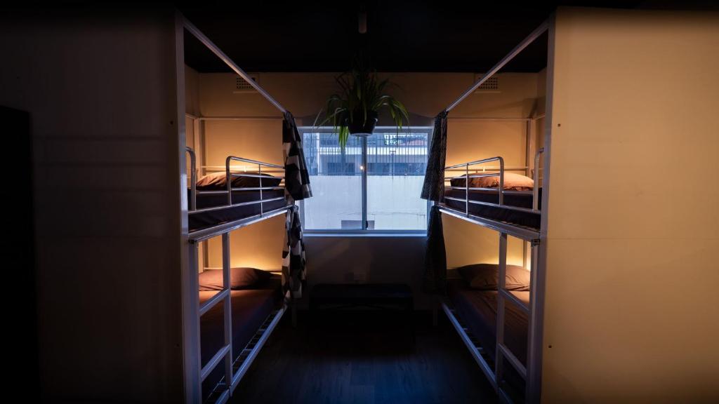 布里斯班Brisbane Quarters的客房设有三张双层床和一扇窗户。