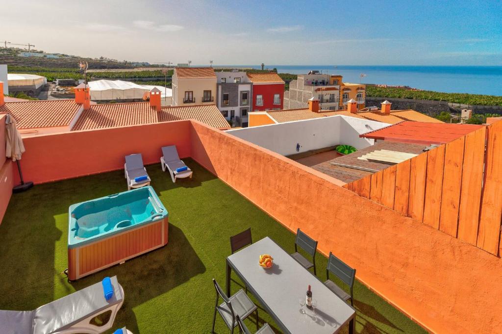 圣胡安海滩Nice House Nina With Jacuzzi的一座橙色的建筑,屋顶上设有游泳池