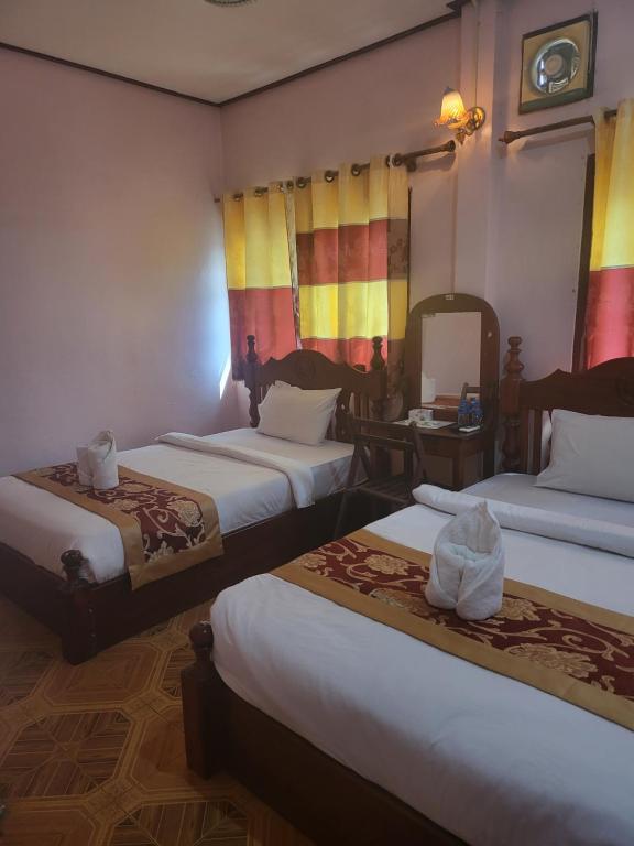 万荣Vang Vieng Chanthala Hotel 1的酒店客房,设有三张床和镜子