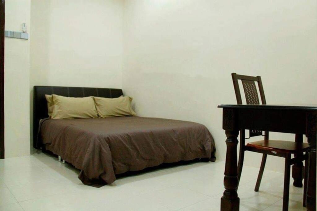 Bukit Kayu HitamHomestay Maya Bukit Kayu Hitam的卧室配有床、书桌和钢琴