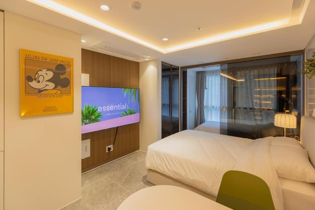首尔Wecostay Gangnam的一间卧室配有一张床和一台平面电视