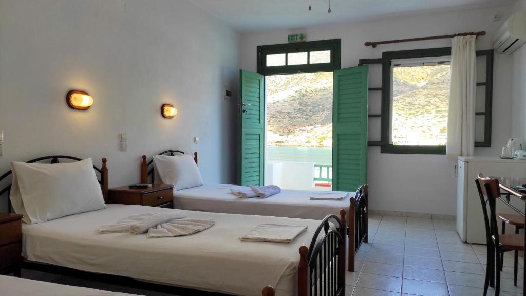 卡马莱Τζαννής Αγλαΐα的带绿色百叶窗的客房内的两张床
