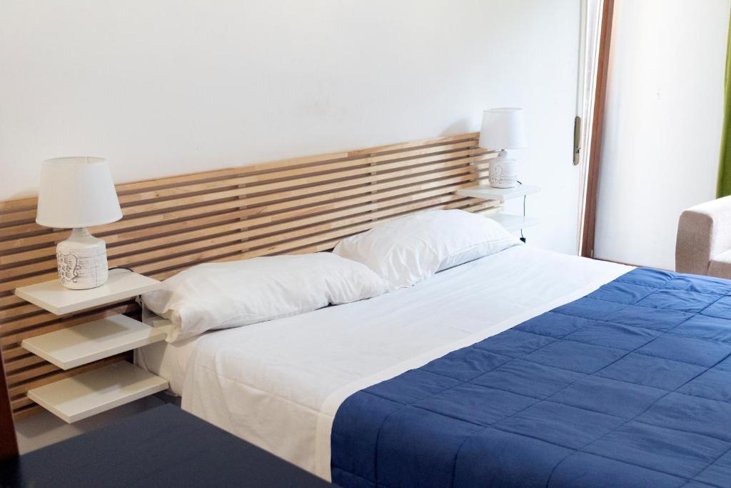 丽都迪奥斯蒂亚La Vittoria的一间卧室配有一张大床和木制床头板