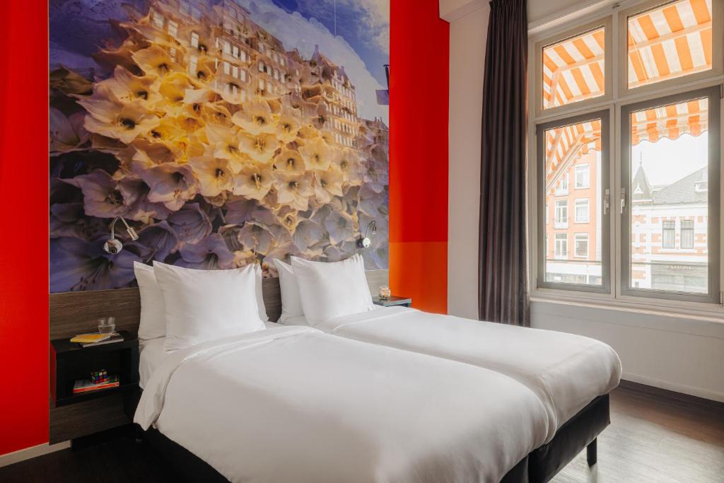 阿姆斯特丹阿姆斯特丹马诺尔酒店的墙上画画的房间里设有两张床