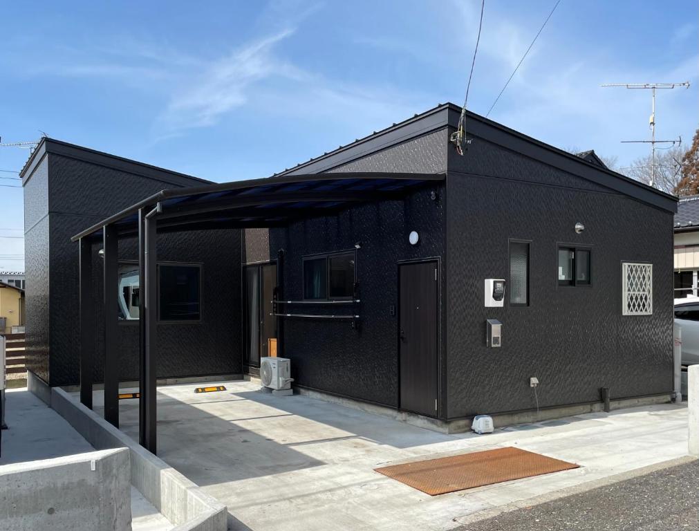 沼田Ittokashivacationrental nuevoL7 - Vacation STAY 83674v的黑色的建筑,有黑色的屋顶