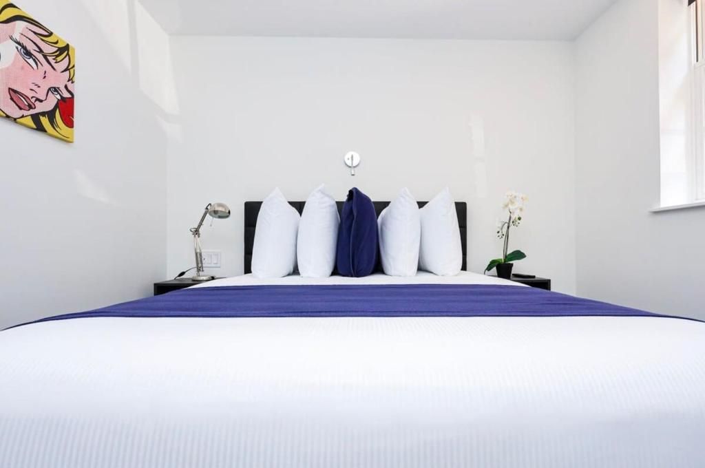 波士顿Modern Studio in Historic Boston - Garden Unit #1的一间卧室配有一张带蓝色床单和白色枕头的床。