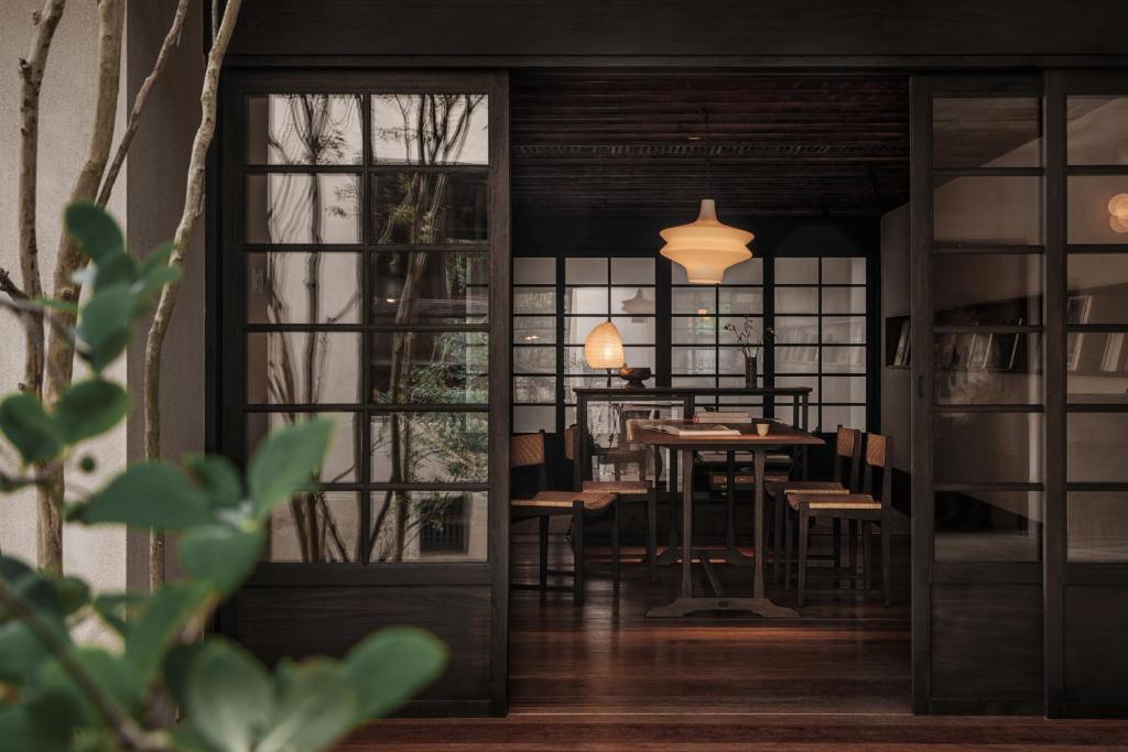 杭州杭州西湖安隅酒店的一间带桌椅和门的用餐室