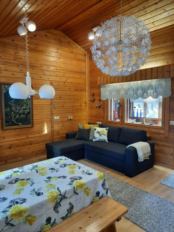 埃农泰基厄Holiday Home Samanitieva的一间卧室配有一张床、一张沙发和一个吊灯。
