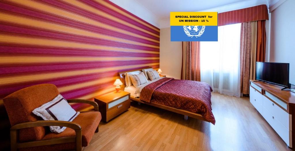 基辅舍伯恩精品公寓酒店的一间卧室设有色彩缤纷的墙壁、一张床和电视。