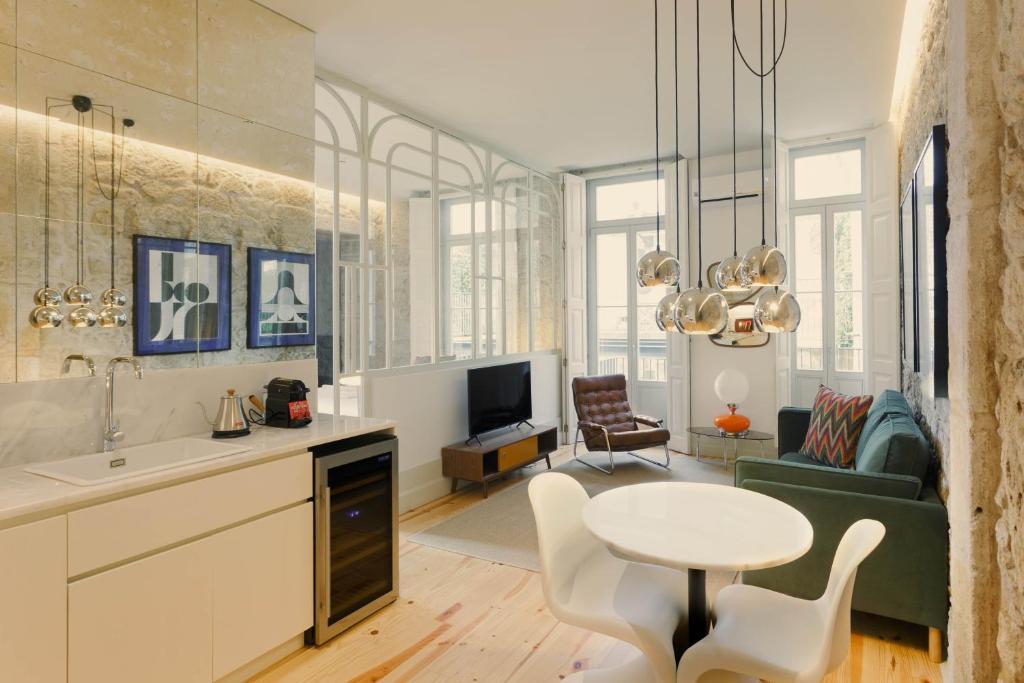 波尔图Laranjais Boutique Suites & Apartments Porto的厨房以及带桌子和沙发的客厅。