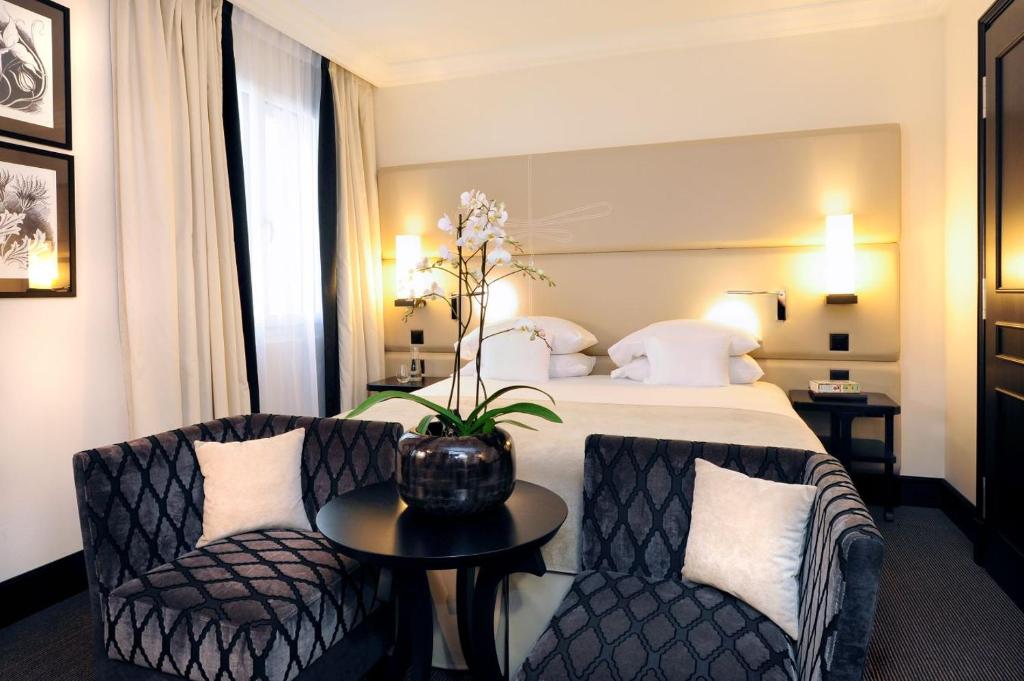 日内瓦蒂凡尼酒店的酒店客房配有一张床、两把椅子和一张桌子